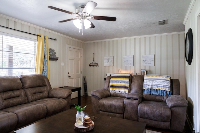 living room featuring a textured ceiling, hardwood / wood-style flooring, ceiling fan, and crown molding