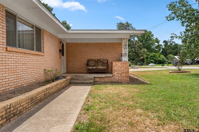 view of exterior entry featuring a yard