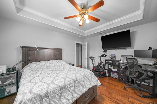 1521 Rice Rd # A105, Tyler, TX 75703 - bedroom with a raised ceiling, wood finished floors, crown molding, a desk, and a ceiling fan