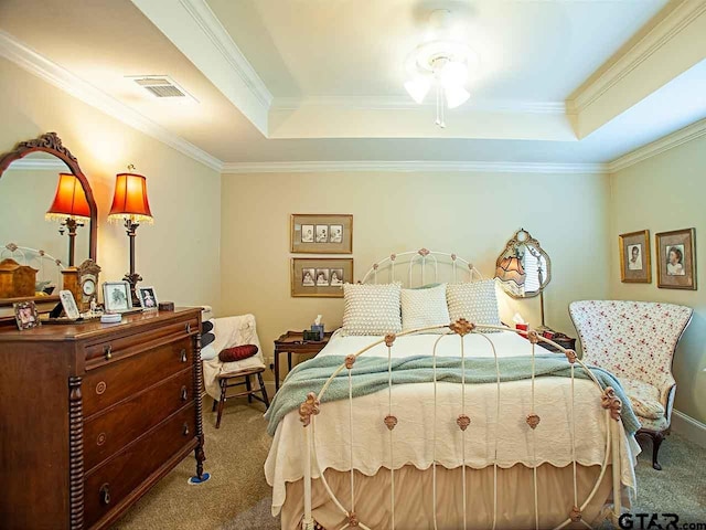carpeted bedroom featuring a tray ceiling, visible vents, and ornamental molding