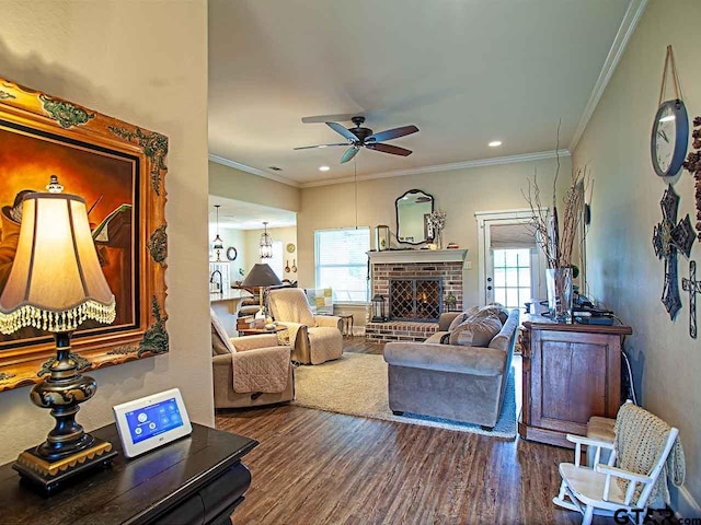 living room featuring a ceiling fan, crown molding, a brick fireplace, wood finished floors, and recessed lighting