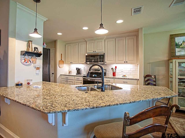 kitchen with visible vents, tasteful backsplash, light stone countertops, and stainless steel appliances