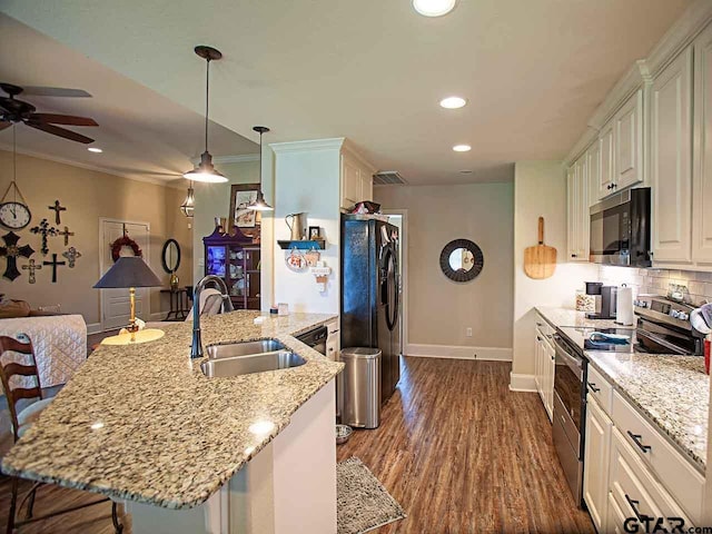 kitchen featuring black refrigerator with ice dispenser, light stone countertops, baseboards, a sink, and stainless steel range with electric cooktop