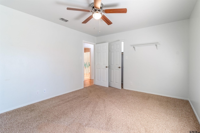 spare room featuring light carpet, baseboards, visible vents, and a ceiling fan