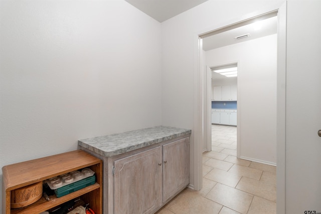 hall with visible vents and light tile patterned floors