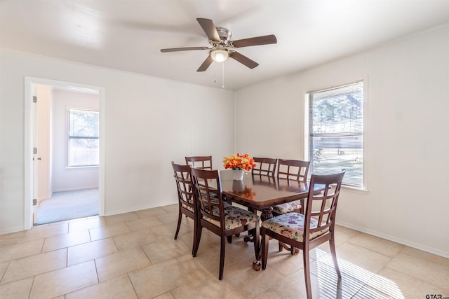 tiled dining room with crown molding and ceiling fan