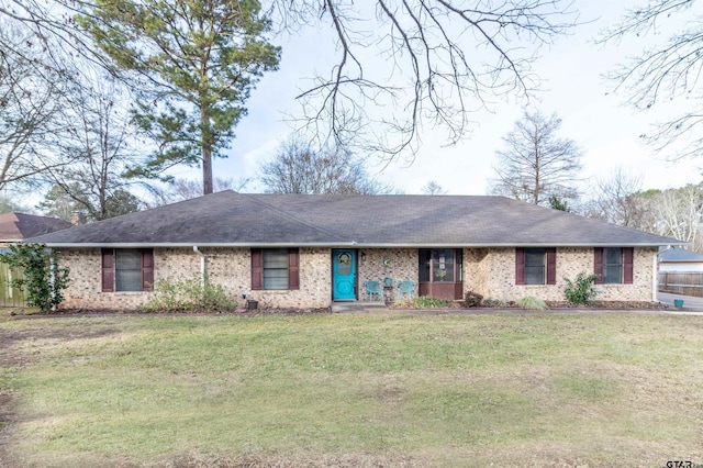 ranch-style house with a front yard, brick siding, and roof with shingles