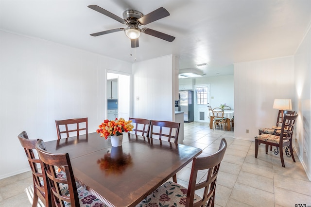 tiled dining space with ceiling fan