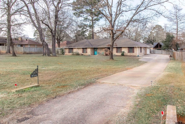 ranch-style house featuring a garage, brick siding, a front yard, and fence