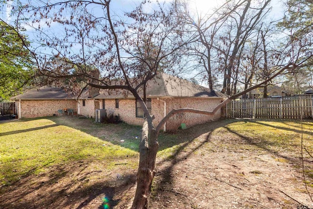 view of side of home featuring central AC and a lawn