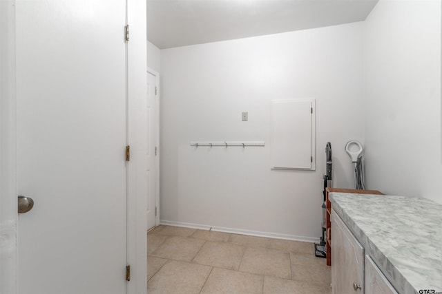 laundry room with light tile patterned floors and baseboards