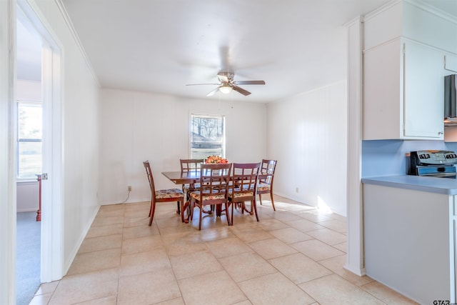 dining area with a ceiling fan, crown molding, and light tile patterned floors