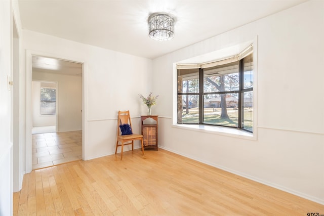 sitting room with baseboards and wood finished floors