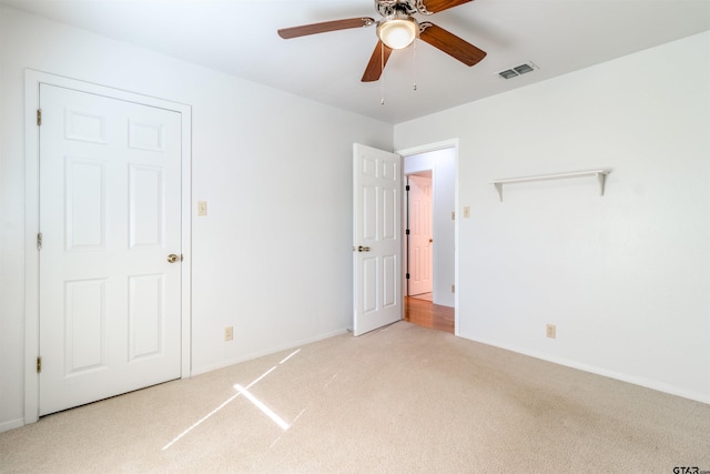 unfurnished bedroom featuring ceiling fan and light colored carpet