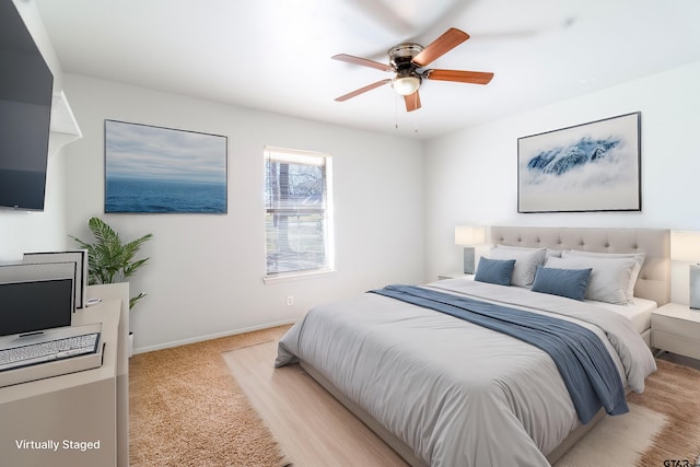 bedroom featuring light carpet, ceiling fan, and baseboards