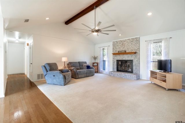 carpeted living room featuring lofted ceiling with beams, plenty of natural light, ceiling fan, and a brick fireplace