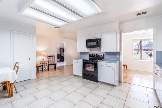 kitchen featuring white cabinetry, ornamental molding, light tile patterned floors, and black appliances