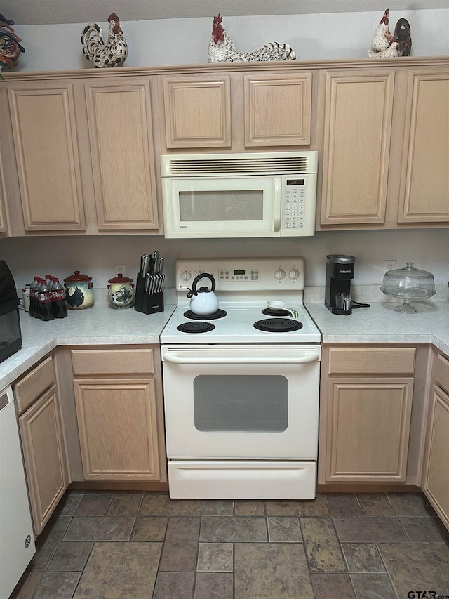 kitchen featuring light brown cabinetry and white appliances