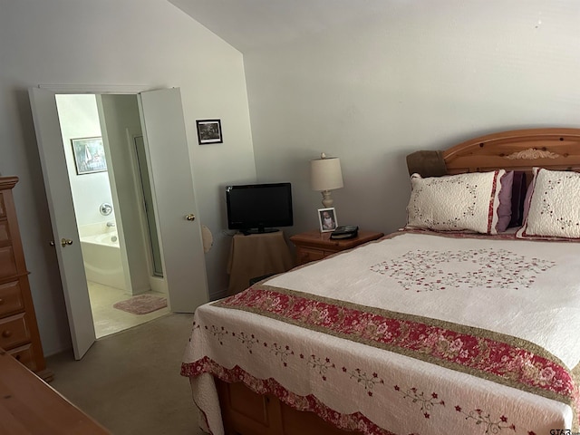 carpeted bedroom featuring ensuite bathroom and vaulted ceiling