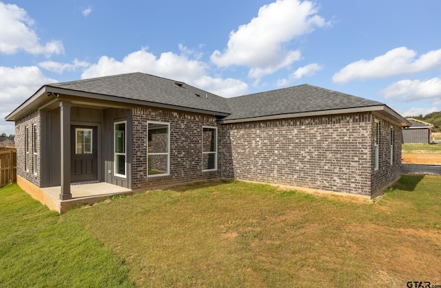 back of house with a patio and a lawn