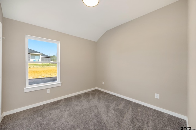 carpeted spare room with vaulted ceiling