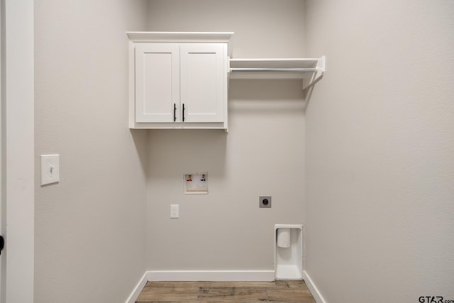 clothes washing area with cabinets, light hardwood / wood-style floors, hookup for a washing machine, and electric dryer hookup