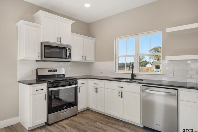 kitchen featuring dark hardwood / wood-style floors, white cabinetry, sink, and appliances with stainless steel finishes