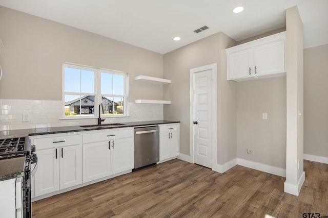 kitchen with stainless steel appliances, sink, backsplash, white cabinets, and dark wood-type flooring