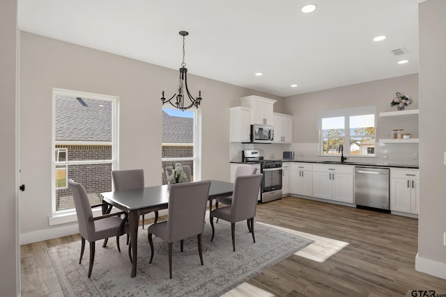 dining room with dark hardwood / wood-style flooring, a notable chandelier, and sink