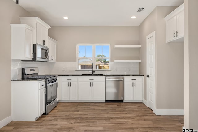 kitchen featuring light hardwood / wood-style floors, white cabinetry, sink, and appliances with stainless steel finishes