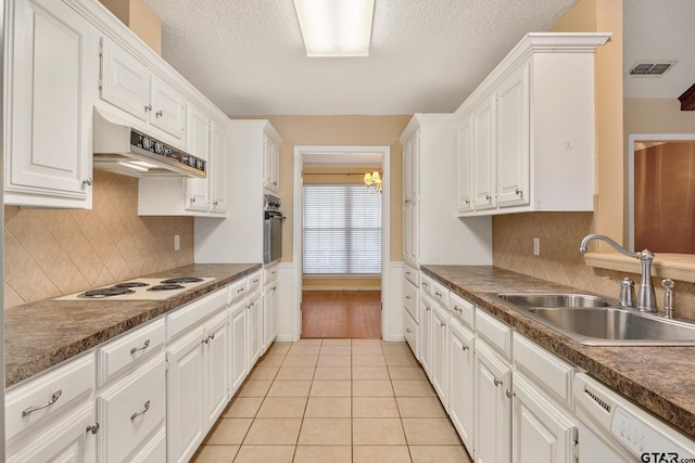 kitchen featuring white cabinetry, sink, light tile patterned floors, white appliances, and a textured ceiling