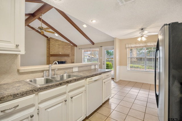 kitchen with stainless steel refrigerator, lofted ceiling with beams, dishwasher, sink, and a textured ceiling