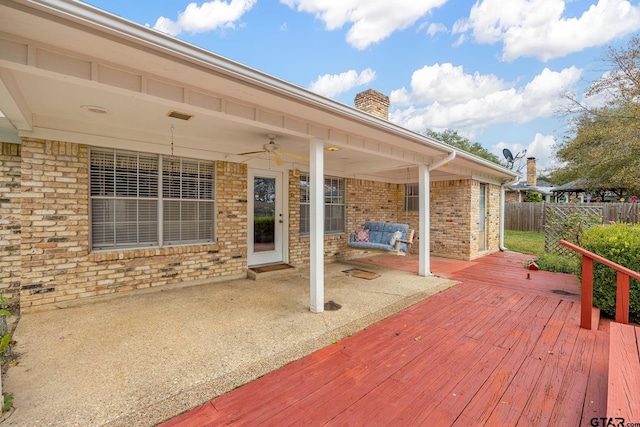 wooden terrace with ceiling fan and a patio