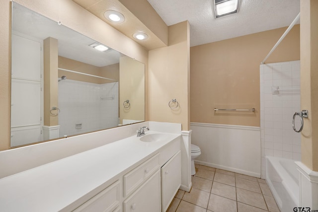 full bathroom with tile patterned floors, toilet, a textured ceiling, vanity, and tiled shower / bath combo