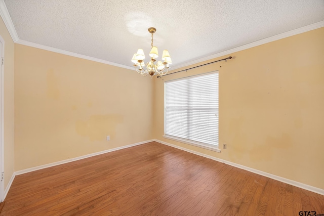 spare room featuring hardwood / wood-style flooring, crown molding, a textured ceiling, and a chandelier