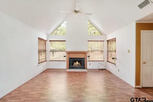 unfurnished living room with hardwood / wood-style flooring, ceiling fan, and high vaulted ceiling