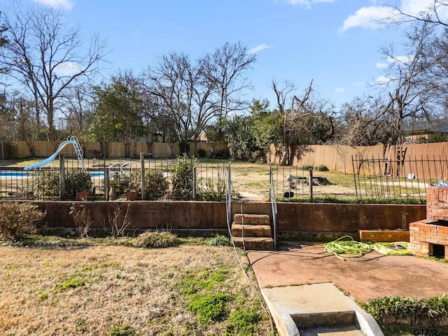 view of yard with an outdoor brick fireplace