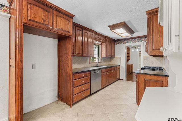 kitchen featuring sink, appliances with stainless steel finishes, backsplash, a textured ceiling, and light tile patterned flooring