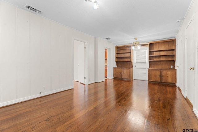 unfurnished living room featuring dark wood-type flooring, ceiling fan, and built in shelves