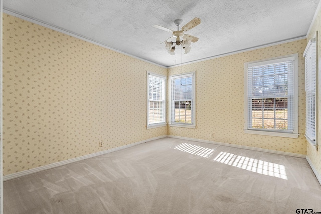 unfurnished room featuring ceiling fan, crown molding, light colored carpet, and a textured ceiling