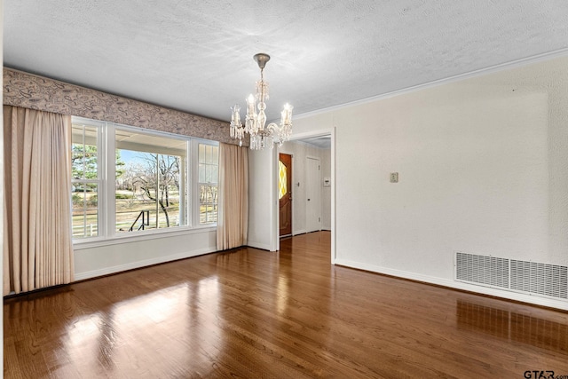 unfurnished dining area with dark hardwood / wood-style flooring, a chandelier, and a textured ceiling