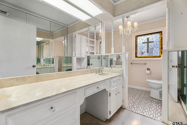 bathroom with crown molding, vanity, an inviting chandelier, and toilet