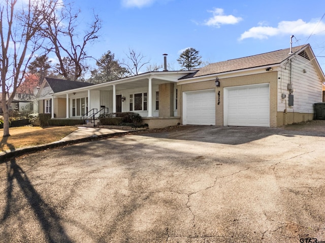 ranch-style home with a garage and covered porch