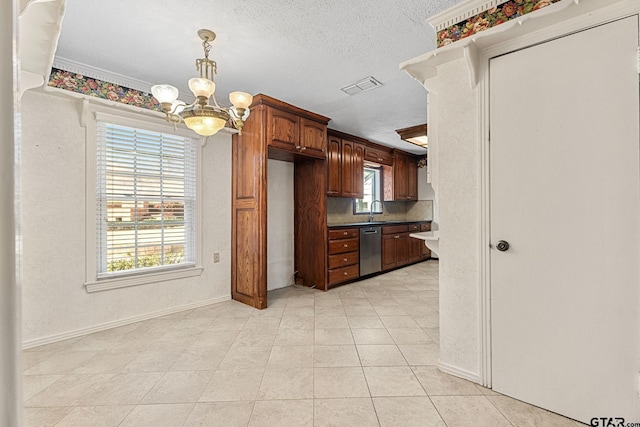 kitchen with sink, a textured ceiling, light tile patterned floors, stainless steel dishwasher, and a notable chandelier