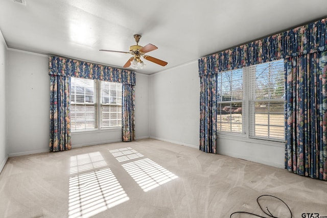 carpeted empty room featuring crown molding and ceiling fan