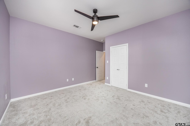 unfurnished bedroom featuring light carpet and ceiling fan