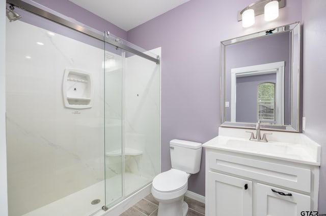 bathroom with walk in shower, vanity, and toilet