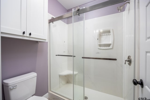 bathroom featuring toilet and an enclosed shower