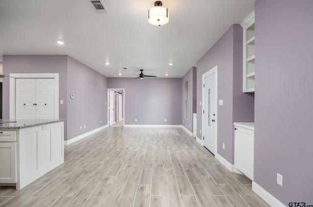 unfurnished living room featuring ceiling fan and light wood-type flooring