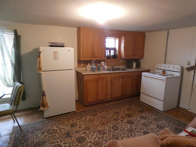 kitchen featuring white appliances, sink, and a textured ceiling